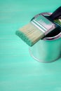 Brush with green paint loves on a paint can Royalty Free Stock Photo