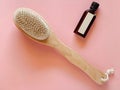 Brush with a handle for dry anti-cellulite massage or brushing in the hand of a girl in soft pink colors.  Beauty concept Royalty Free Stock Photo