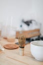 A brush made of bamboo and a teacup with green tea called matcha on wooden tray made by professional barista in Asian cafe. Royalty Free Stock Photo