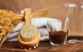 Brush massage counter, washcloth for shower with double nozzles with bunch of dried straw and natural coffee scrub in glass, towel