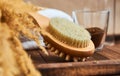 Brush massage counter, washcloth for shower with double nozzles with bunch of dried straw and natural coffee scrub in glass, towel