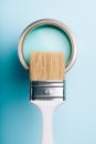 Brush on open can of turquoise paint on blue pastel background. Royalty Free Stock Photo