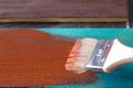 Brush with paint in hand. A man paints blue boards in a brown paint brush. Royalty Free Stock Photo