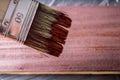 Brush with paint in hand. A man paints blue boards in a brown paint brush. Royalty Free Stock Photo