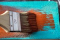 Brush with paint in hand. A man paints blue boards in a brown paint brush. Royalty Free Stock Photo