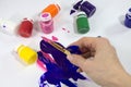 Brush with paints for painting, in a female hand. Royalty Free Stock Photo