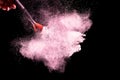 Brush with pink powder explosion on black background.Make-up and beauty concept Royalty Free Stock Photo