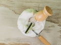 A brush and a razor with wooden handles in a coconut bowl with shaving foam. Flat lay