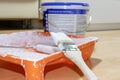 Brush and roller in used orange paint tray, paint can on background. Apartment repair, painting and design concept. Royalty Free Stock Photo