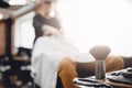 Brush for shaving beard along with bowl, blurred background of hair salon for men, barber shop Royalty Free Stock Photo