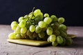 a brush of table white grapes on a cutting board on a dark background Royalty Free Stock Photo
