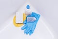 Brush, washcloth and rubber gloves in white bath Royalty Free Stock Photo