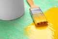 Brush with yellow paint on green wooden background, Royalty Free Stock Photo