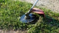 Brushcutter with sharp blade. Lawnmowing grass with brushcutter. Grass mowing.