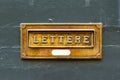 Brushed copper letter box on old painted wood