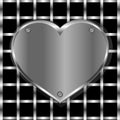 Brushed metal heart on a perforated background