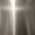 Brushed metallic surface with a soft cross-like light reflection at its center. The texture Royalty Free Stock Photo