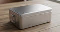 Brushed silver metal rectangular lunch box with a hinged handle on a warm wooden table surface Royalty Free Stock Photo