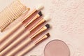 Brushes for applying powder, eye shadow and lip gloss on a beige background Royalty Free Stock Photo