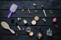 Brushes and combs, perfumes and various cosmetics and flowers lie on a black wooden board, cosmetics as a background