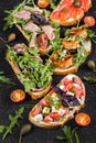 Brushetta set for wine. Variety of small sandwiches with prosciutto, tomatoes, parmesan cheese, fresh basil Royalty Free Stock Photo