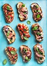 Brushetta set for wine. Variety of small sandwiches on turquoise blue backdrop, top view