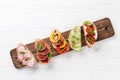 Brushetta or traditional spanish tapas. Appetizers italian antipasti snacks set on wooden board. Top view and flat lay with space