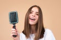 Brushing Hair. Portrait young woman brushing straight natural hair with comb. Girl combing long healthy hair with