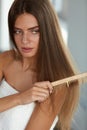 Brushing Hair. Woman Hairbrushing Beautiful Long Hair With Comb Royalty Free Stock Photo