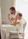 Brushing teeth, father and child in a bathroom at home in morning with dental cleaning. Oral hygiene, kids and dad