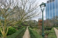 Old street lantern and green park area around orangery and urban city building towers