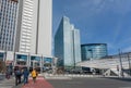 Street with crossing people past skyscrapers and other modern glass and steel buildings of urban city