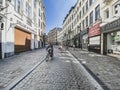 Brussels, Belgium, April 25, 2020 - .Rue marchÃÂ© aux herbes, a family cyclists on a deserted street in the old quarter of Brussels