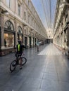 Brussels, Belgium, April 25, 2020 - two cyclist inside the empty luxury glazed shopping arcade Les Galeries Royales Saint-Hubert