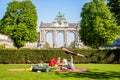 A couple is practicing acroyoga in the Cinquantenaire park in Brussels, Belgium