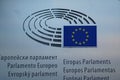 Multilingual sign and EU flag on European Parliament building in Brussels