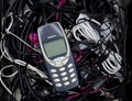 Brussels, Belgium - February 26, 2017 : The iconic Nokia 3310 mobile phone photographed on a pile of old charging cables.