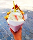 Woman is holding famous traditional Belgium fries in Brussels street