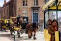 People touring around the beautiful Bruges town on a carriage pulled by a horse