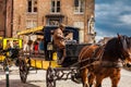 People touring around the beautiful Bruges town on a carriage pulled by a horse