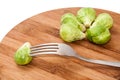 Brussels sprouts on a kitchen board and one pierced with a fork Royalty Free Stock Photo