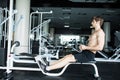 Brutal athletic man pumping up muscles on crossover. Muscular man working out in gym doing exercises . gym