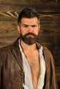 Brutal attractive man. Barber and hairdresser salon. Barber man with stylish hipster beard on wooden background