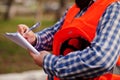 Brutal beard worker man suit construction worker in safety orange helmet, with plan paper at hands. Royalty Free Stock Photo