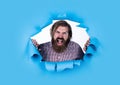 Brutal bearded man shouting. angry man torn blue background. male hipster express anger. aggressive mature guy. express