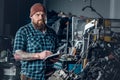 Mechanicl inspecting engine of a car in a garage.