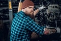 Mechanicl inspecting engine of a car in a garage.