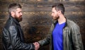 Brutal bearded men wear leather jackets shaking hands. Friendship of brutal guys. Approved business deal. Handshake Royalty Free Stock Photo