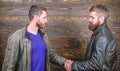 Brutal bearded men wear leather jackets shaking hands. Friendship of brutal guys. Approved business deal. Handshake Royalty Free Stock Photo