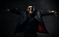 Brutal business man gangster with beard and mustache in sunglasses cap and leather wear jacket with raised hands Royalty Free Stock Photo